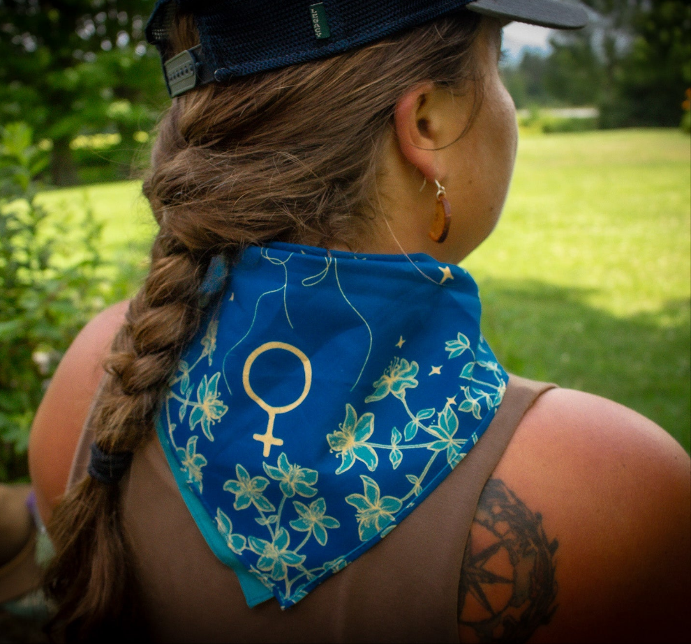 Woman wearing a blue and yellow bandana backwards to shade her neck