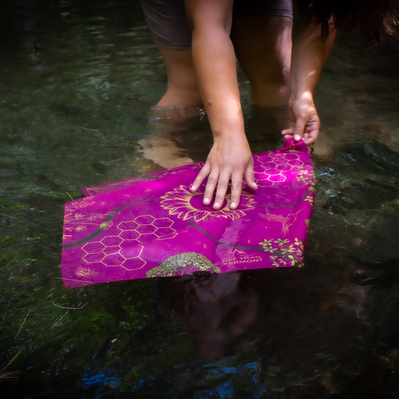 soaking a pink bandana in water to cool off