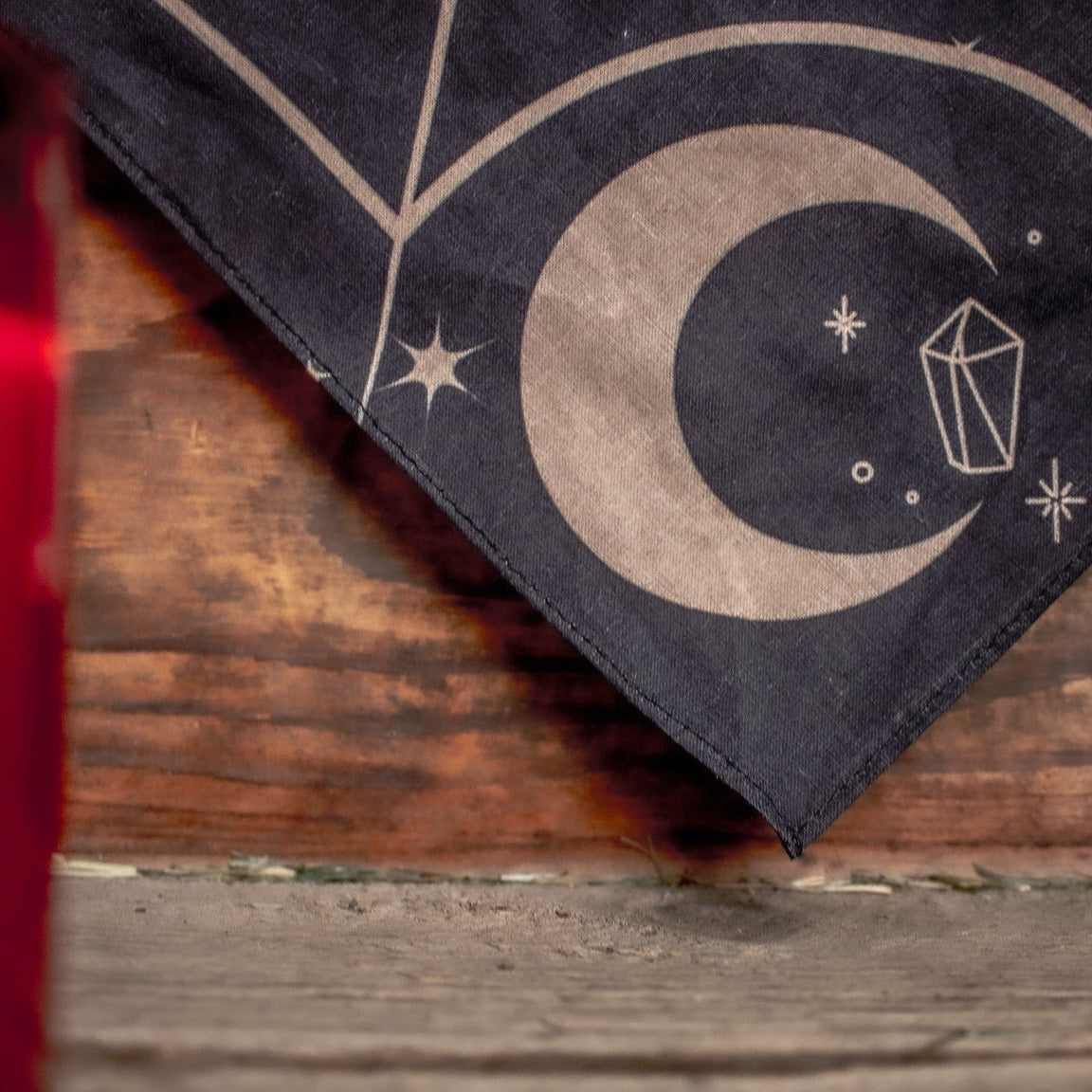 Black bandana with celestial design on a wooden surface