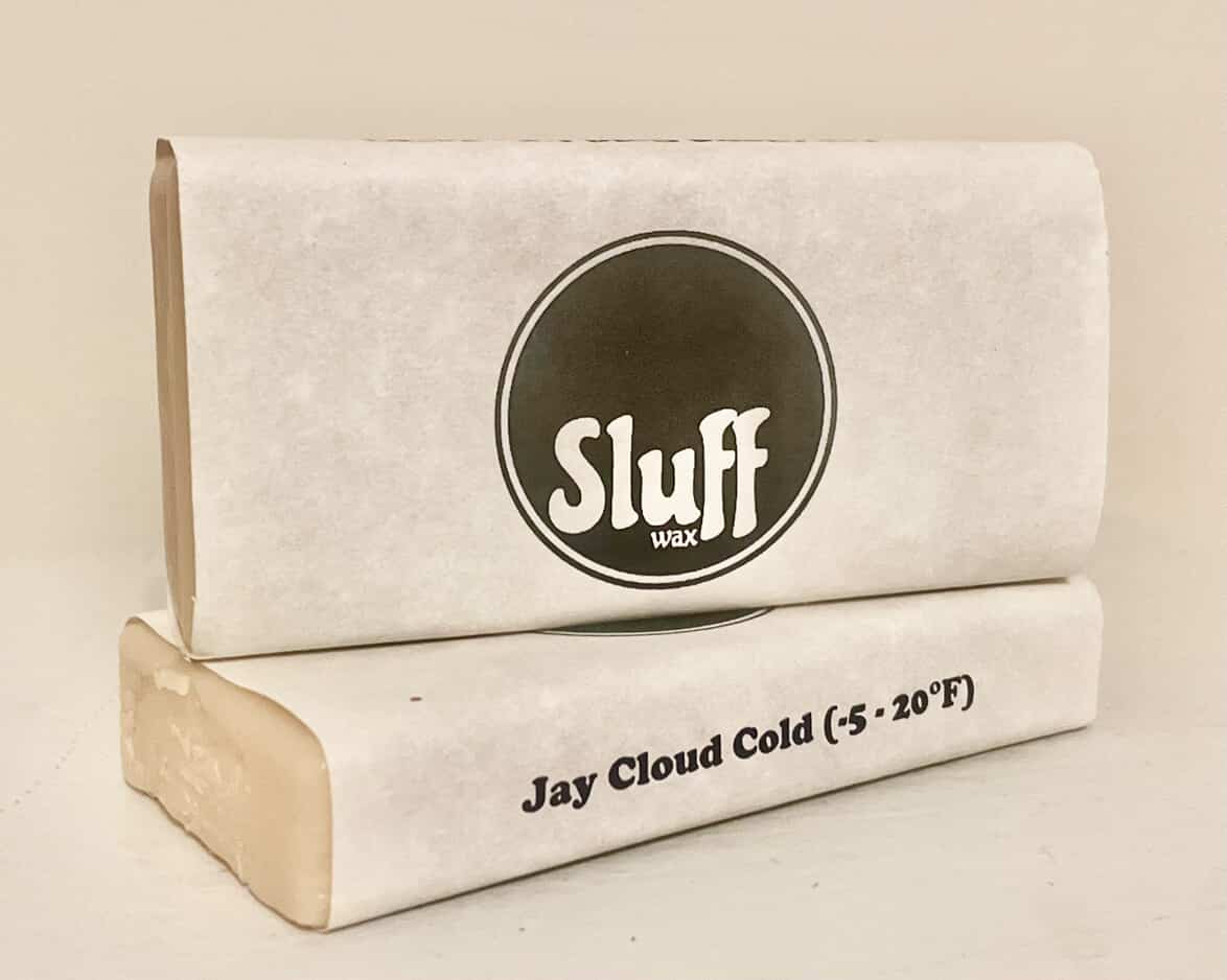 Two packages of Sluff wax on a beige background