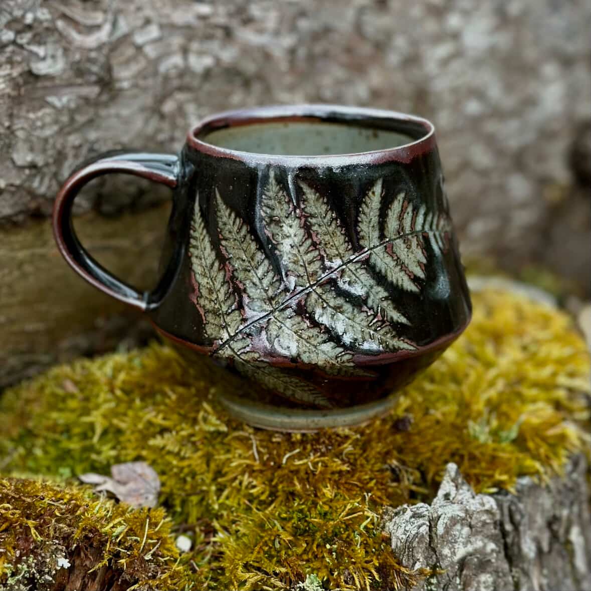 made in Vermont Ceramic mug with leaf pattern on a mossy surface