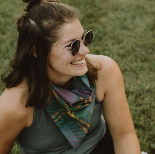 Cute circle sunglasses and purple plaid bandana on woman sitting on the green